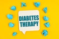 On a yellow background, blue pieces of paper and a sign with the inscription - DIABETES THERAPY