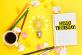 On a yellow background, a cup of coffee, a light bulb, pencils, a notebook with the inscription - HELLO THURSDAY