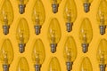 Yellow background. Electric light bulbs pattern. An old glass electric light bulb with a tungsten filament. The concept Royalty Free Stock Photo