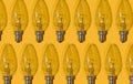 Yellow background. Electric light bulbs pattern. An old glass electric light bulb with a tungsten filament. The concept Royalty Free Stock Photo