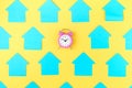 On a yellow background, empty turquoise stickers in the form of houses. In the center is a small pink alarm clock