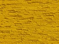 Yellow background facade plaster . Monolithic plaster decorative backdrop. Single layer scraped cement plaster wallpaper. Sand ext