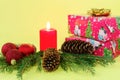 On a yellow background, New Year`s gift boxes with green spruce branches and red decorative balls. Royalty Free Stock Photo