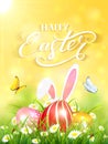Yellow background with rabbit and three Easter eggs in grass Royalty Free Stock Photo