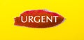 On a yellow background, a sheet of red paper with the word URGENT