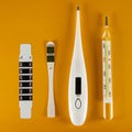 On a yellow background, there are four types of thermometers - liquid crystal, clinical, electric and mercury. Concept of health