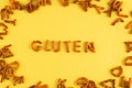 On a yellow background, the word gluten is folded from cookies. The concept of carbohydrates