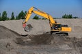 Backhoe digging for a storage tank foundation.