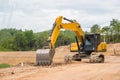 Yellow backhoe excavating soil and sand