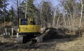 Yellow backhoe excavator near utility boxes at construction site