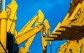 Yellow backhoe with hydraulic piston arm against clear blue sky. Heavy machine for excavation in construction site. Hydraulic Royalty Free Stock Photo