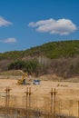 Yellow backhoe and loaded dump truck