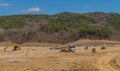 Yellow backhoe and loaded dump truck