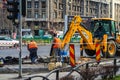 Yellow backhoe loader and workers on construction site ready for working in Bucharest, Romania, 2020