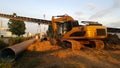 Yellow backhoe near the new water pipeline