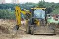 Yellow backhoe on working site.