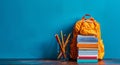 Yellow Backpack on Books on Blue Background Royalty Free Stock Photo