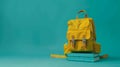 Yellow Backpack and Books on Turquoise Background with Copy Space Royalty Free Stock Photo