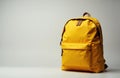 A yellow backpack standing upright on a plain light background Royalty Free Stock Photo