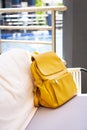 A yellow backpack sits on a soft sofa. Rest from study in a cafe, a break for food Royalty Free Stock Photo