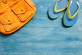 Yellow backpack and slippers on a blue wooden table, top view an Royalty Free Stock Photo