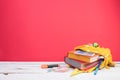 Yellow backpack with white polka dots with different colorful stationery on table. Bright Red background. Back to school Royalty Free Stock Photo