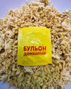 Yellow bag of seasoning on a block of dried instant noodles close-up.