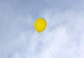 Yellow balloon flying on a blue sky background Royalty Free Stock Photo