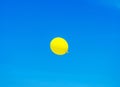 yellow balloon flying into sunny blue sky Royalty Free Stock Photo
