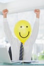 Yellow balloon with happy face hiding cheerful businessmans face