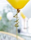 Yellow baloon with tape. Golden rope.