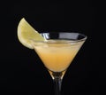 Yellow banana cocktail in martini glass with lemon slice on black Royalty Free Stock Photo