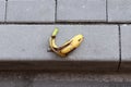 Yellow banana peel on a paved road Royalty Free Stock Photo