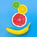 Yellow banana and slices of grapefruit, lemon and lime on a blue background Royalty Free Stock Photo