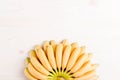 Yellow bananas baby tips down below fan on top of the light boar Royalty Free Stock Photo