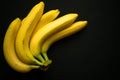Yellow bananas on a black background. Copy space.