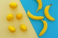 Yellow bananas and lemons on bright blue paper, trendy flat lay. Royalty Free Stock Photo