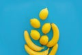 Yellow bananas and lemons on bright blue paper, trendy flat lay. Royalty Free Stock Photo