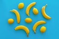 Yellow bananas and lemons on bright blue paper, trendy flat lay. Royalty Free Stock Photo