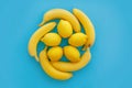 Yellow bananas and lemons in circle on bright blue paper, trendy Royalty Free Stock Photo