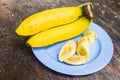 Ripe yellow bananas served with a wooden table background.
