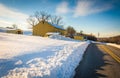 Yellow barn and a snow covered field along a country road in York County, Pennsylvania.