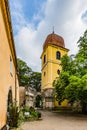 Yellow baroque bell tower with red roof