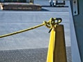 Yellow barrier rope attached to metal post with knot