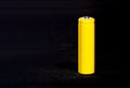 A yellow battery close-up on a dark black blurred background. Electrics. Battery power.  Accumulator on the fabric with villi. Royalty Free Stock Photo