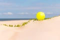 Yellow beach ball on the sand by the water on a sunny day. Copy space for text. Vacation background Royalty Free Stock Photo