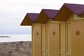 Yellow beach cabins in the bathhouse on the sand with Mediterranean sea in background Italy, Europe