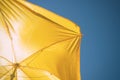 Yellow beach umbrella against the blue sky, protection from the scorching sun Royalty Free Stock Photo