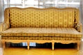 Yellow beautiful vintage sofa stands in the room