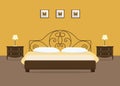 Yellow bedroom with a brown bed and bedside tables Royalty Free Stock Photo